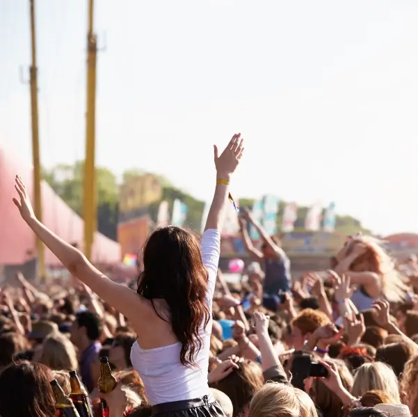 woman in a crows on someone's shoulders at a music festival